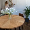 FJÄRIL LUMI handmade wooden table with starburst pattern Solid oak and veneer star-pattern table top interacting with sunlight